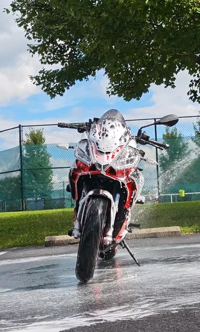 Aprilia sport bike covered in thick foam during a wash