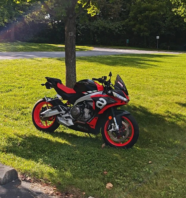 Clean Aprilia sport bike with red wheels after detailing